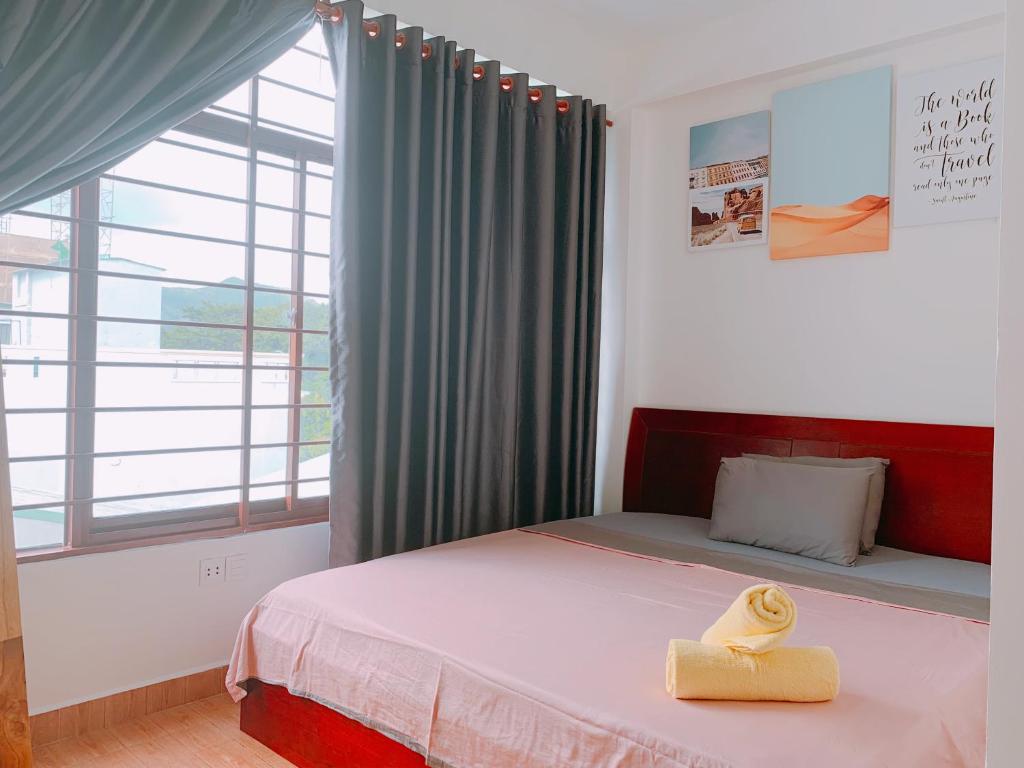a bedroom with a bed and a large window at Lan Anh's Home in Con Dao