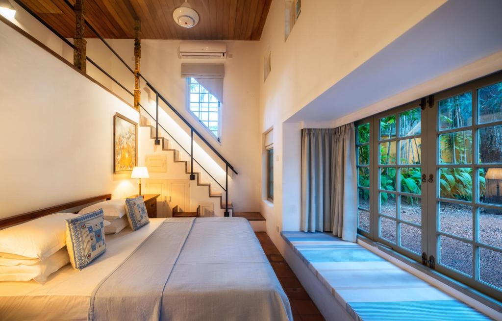 a bedroom with two beds and a large window at De Saram House by Geoffrey Bawa in Colombo