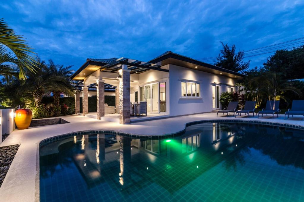 una piscina frente a una casa por la noche en Orchid Paradise Homes 312, en Hua Hin
