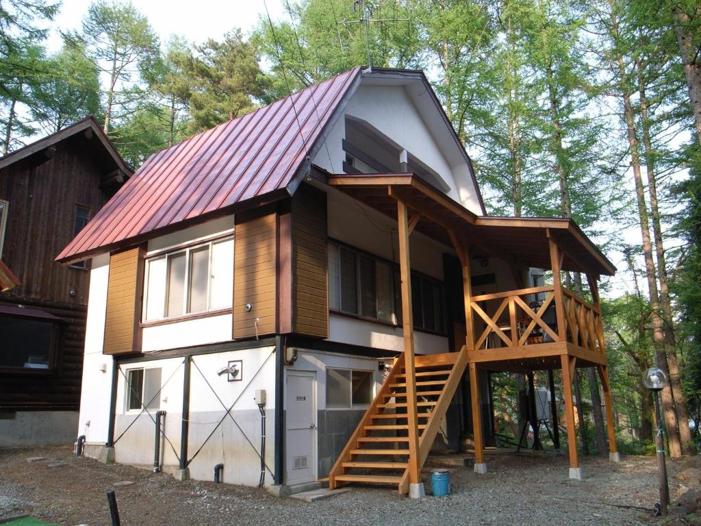 Cottage All Resort Service / Vacation STAY 8369 في Inawashiro: منزل صغير فيه كراج وسقف احمر