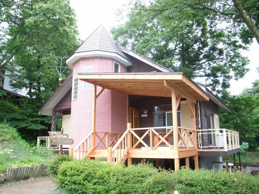 a small pink house with a porch and a balcony at Cottage All Resort Service / Vacation STAY 8399 in Inawashiro