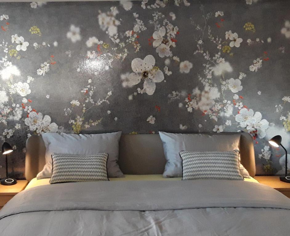 a bedroom with a bed with flowers on the wall at Appartement Säntisblüte in Rehetobel