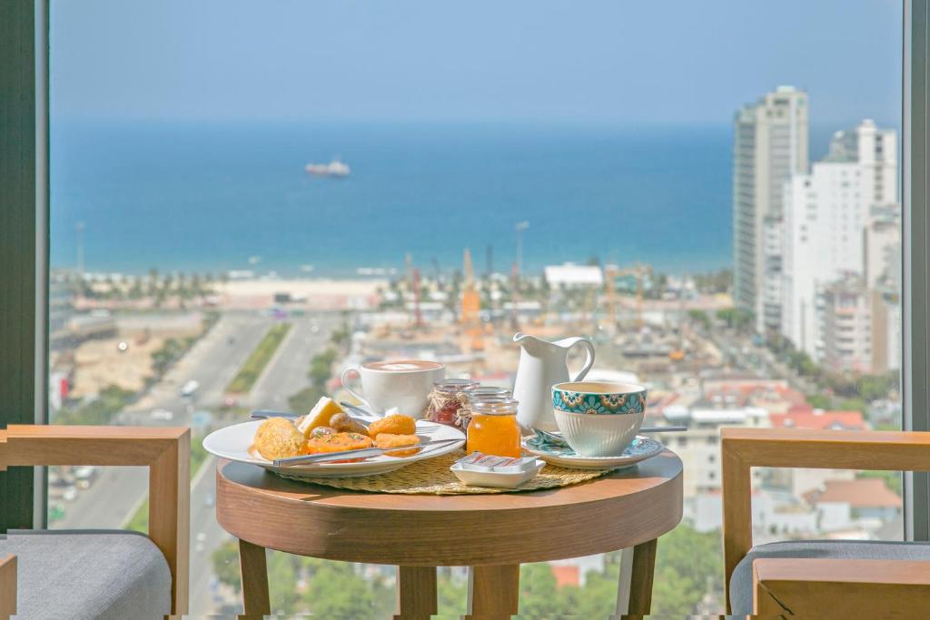 Breakfast is set on a small round table facing a broad coastal city view.