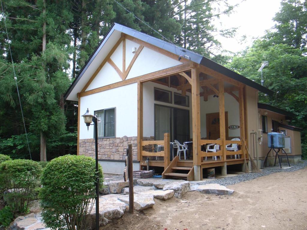 a tiny house in the woods with a porch at Cottage All Resort Service / Vacation STAY 8401 in Inawashiro