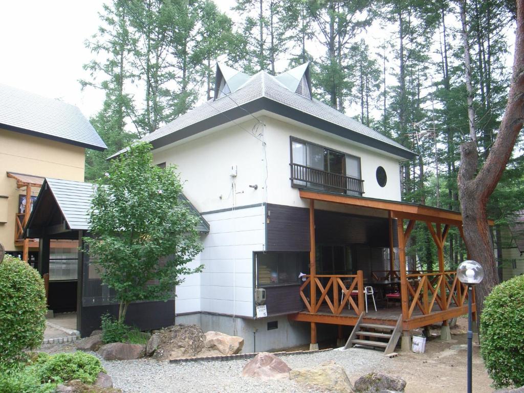 een wit huis met een veranda en een balkon bij Cottage All Resort Service / Vacation STAY 8406 in Inawashiro
