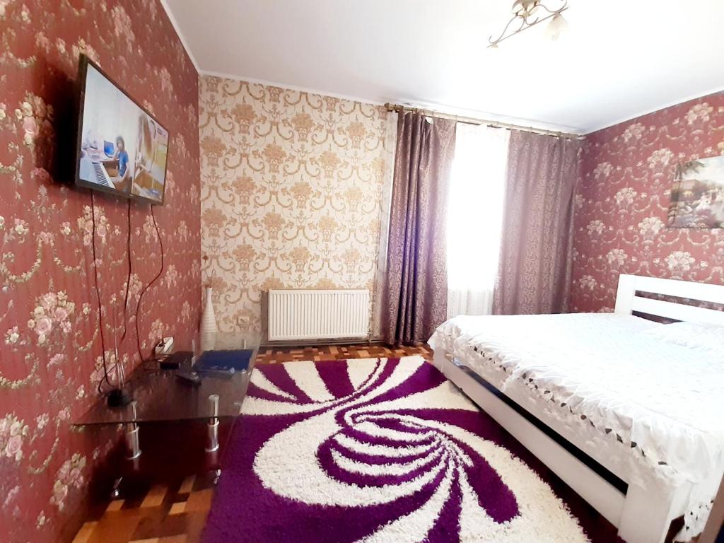 クロプィウヌィーツィクィイにあるЯновского 3кの紫色のカーペットフロアのベッドルーム1室(ベッド1台付)