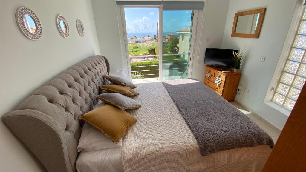 a large bed in a room with a large window at Roof Terrace & Sea View Entire Apartment in Peyia