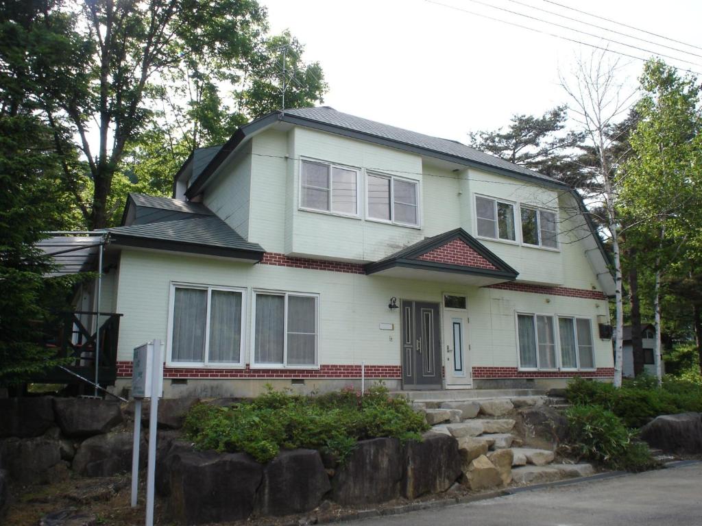 una casa blanca con techo negro en Cottage All Resort Service / Vacation STAY 8435 en Inawashiro