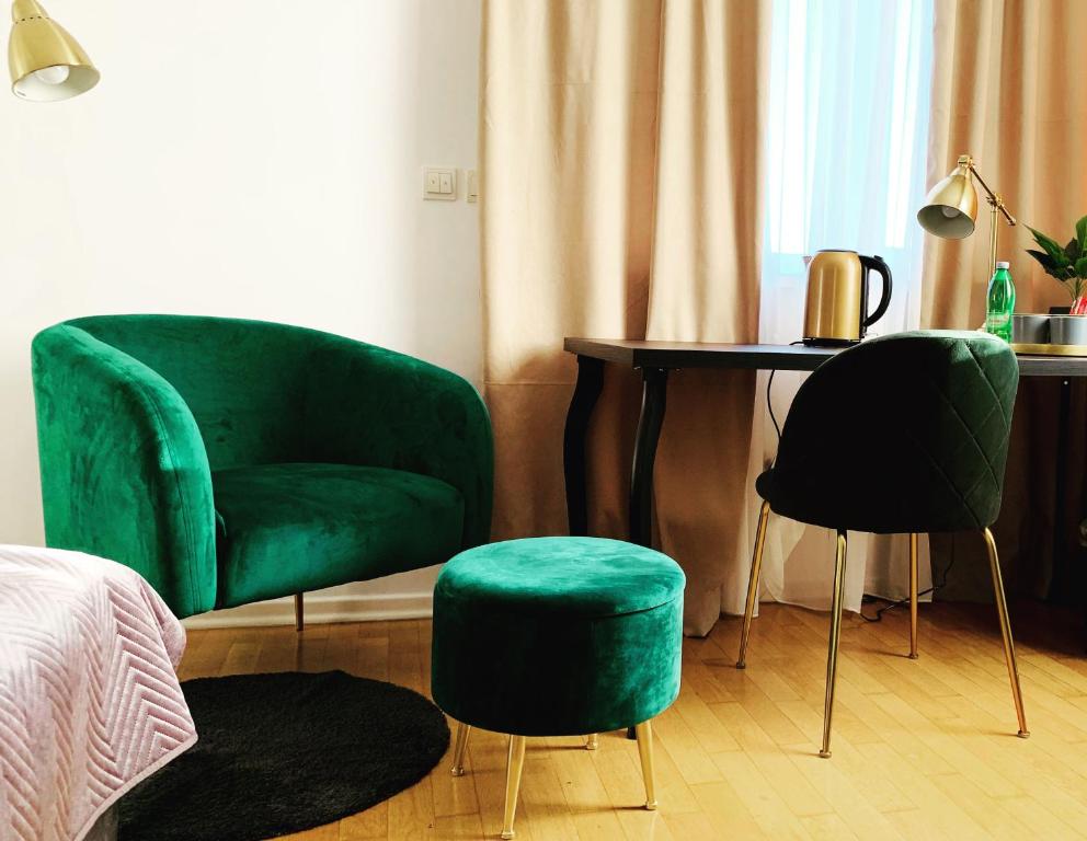 um quarto com duas cadeiras verdes e uma mesa em Best West Sveta Nedelja em Sveta Nedjelja