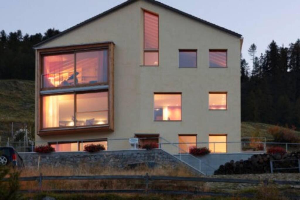 Una casa con luces en las ventanas. en Ferienwohnung Chasa Arpiglia, en Guarda