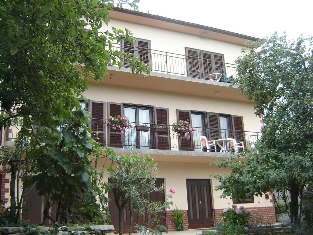 - un bâtiment avec un balcon fleuri dans l'établissement Apartments Grgorinić - Ground Floor, à Pula