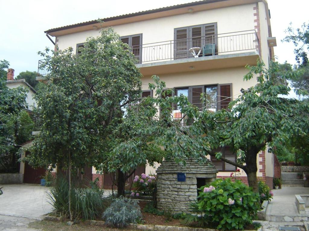 una casa con balcón y árboles frente a ella en Apartments Grgorinić 3 bedrooms, en Pula