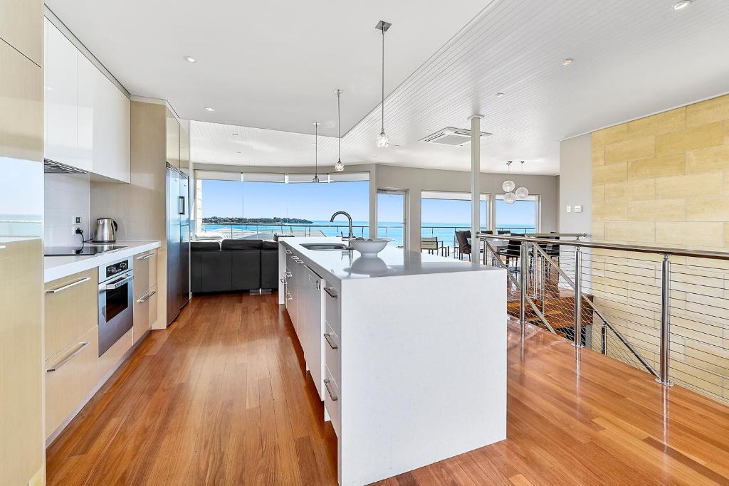 a kitchen with white appliances and a balcony with the ocean at Aloha Highview in Robe