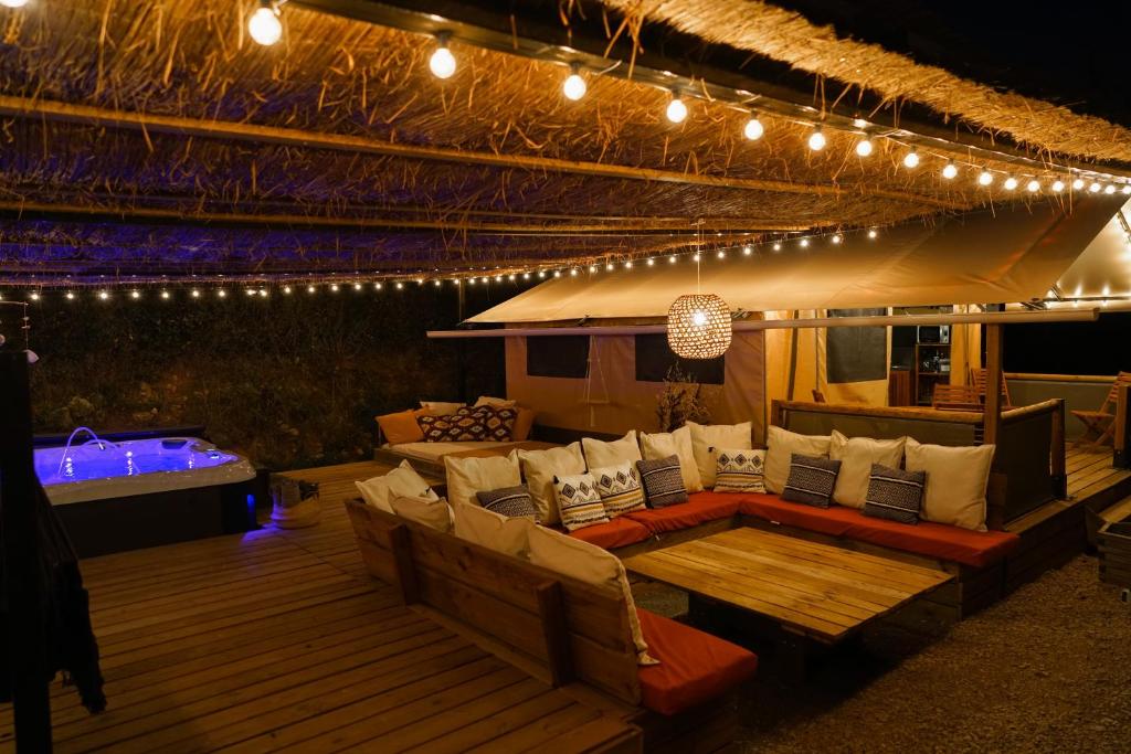 d'une terrasse avec un canapé, une table et des lumières. dans l'établissement Cabane Ayana, à Saint-Maximin-la-Sainte-Baume