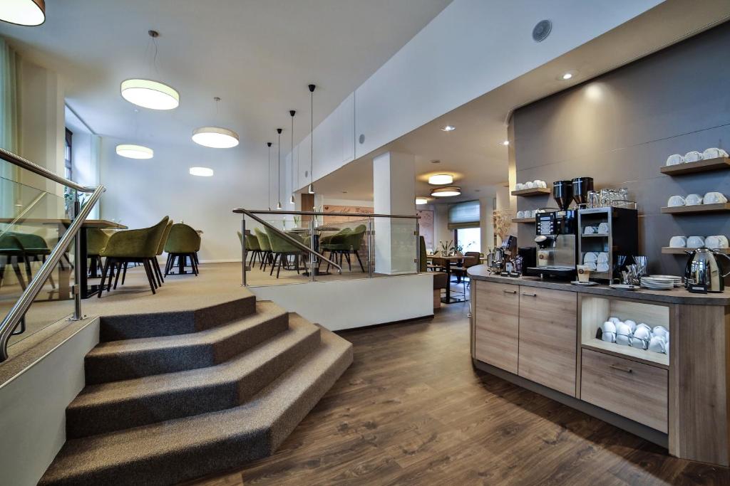 een lobby met een trap en een koffiebar bij City Partner Hotel Berliner Hof in Karlsruhe