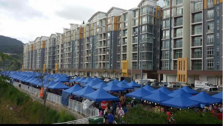 a large building with blue umbrellas in front of it at Barrington Square 2 Rooms Apartment at Golden Hill Night Market in Brinchang