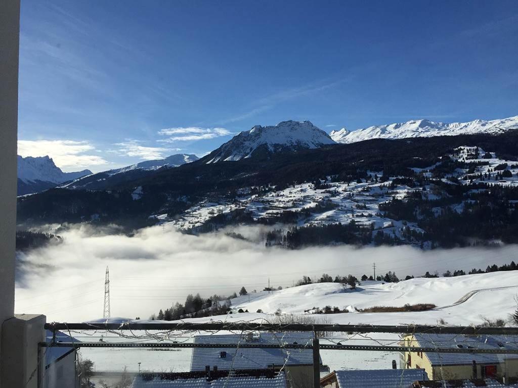 Blick auf einen schneebedeckten Berg mit Stadt und Wolken in der Unterkunft Ferienwohnung Vazerol in Brienz