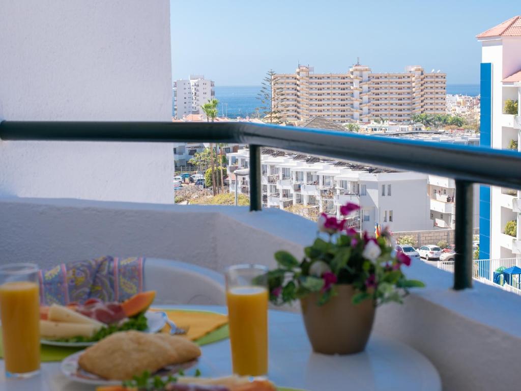 a table with food and orange juice on a balcony at 427 BEAUTIFUL SUMMERLAND STUDIO Wi-Fi Sat-Tv in El Guincho