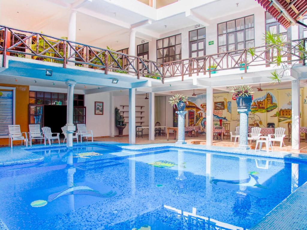 a large swimming pool in a hotel with a balcony at Hotel Bello Caribe in Cozumel