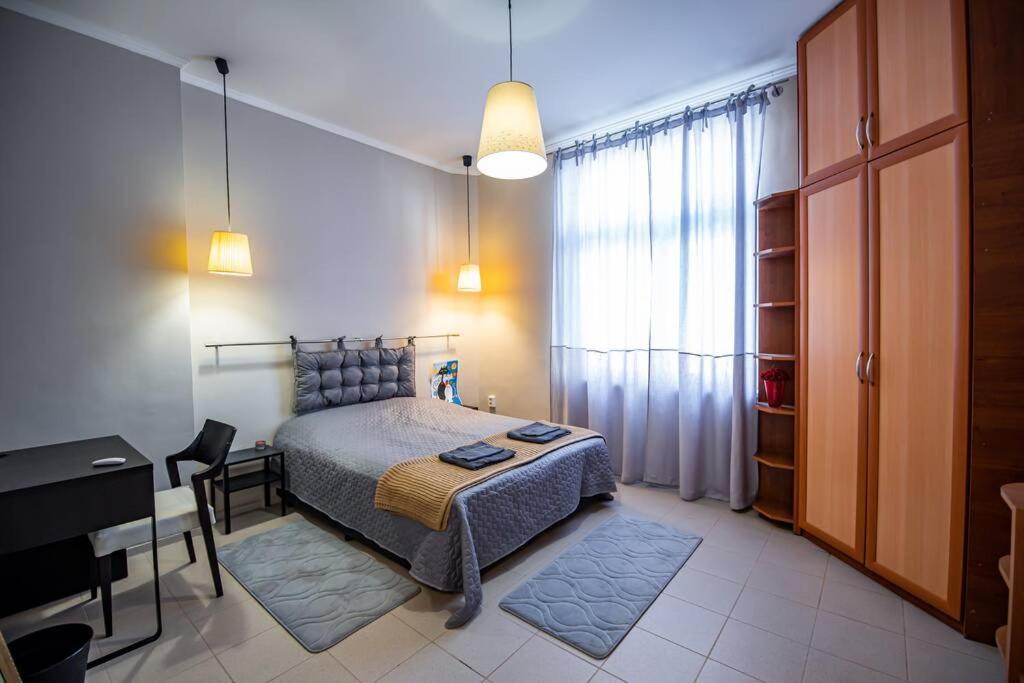 a bedroom with a bed and a table and a desk at Huge Stylish Apartment Monroe 1 / City Centre in Plovdiv