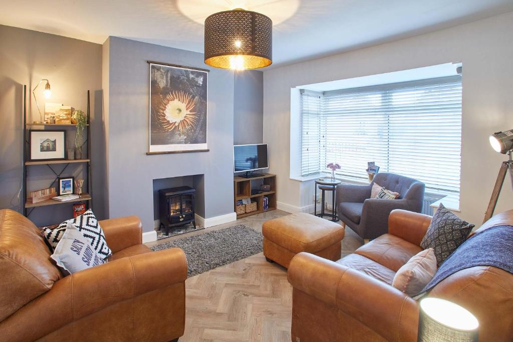 a living room with leather furniture and a fireplace at Host & Stay - Willow View in Saltburn-by-the-Sea