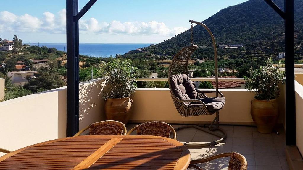 una mesa y sillas en un balcón con vistas al océano en Sea Flower Villa Bali Crete, en Vlikhádha