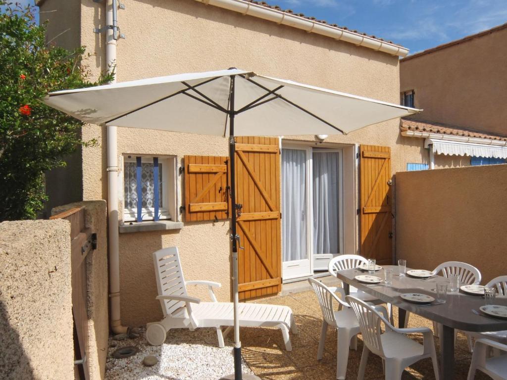un parapluie blanc assis au-dessus d'une table dans l'établissement Holiday Home Les Capellanes-3 by Interhome, à Saint Cyprien Plage