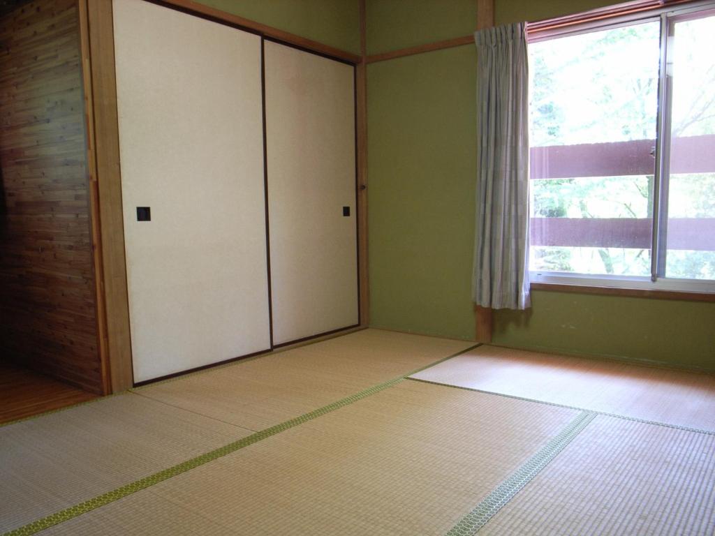 Cottage All Resort Service / Vacation STAY 8369 في Inawashiro: غرفة فارغة بها خزانتين ونافذة