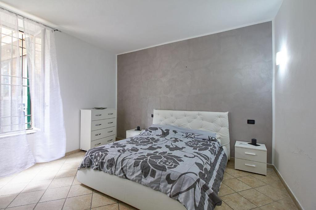 1 dormitorio con cama y ventana grande en Appartamento Ulivo, en Finale Ligure