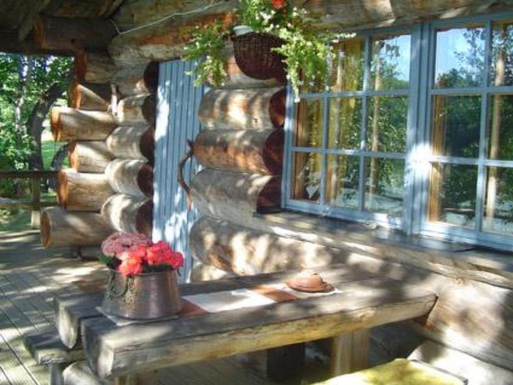 una baita di tronchi con panchina di fronte a una finestra di Holiday Home Veijon kelo by Interhome a Korpilahti