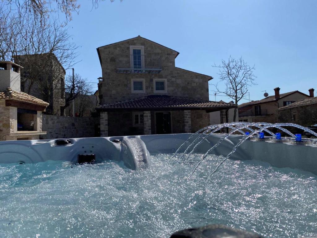 a pool with a water fountain in a yard at Casa di nonno Giovanni in Buzet