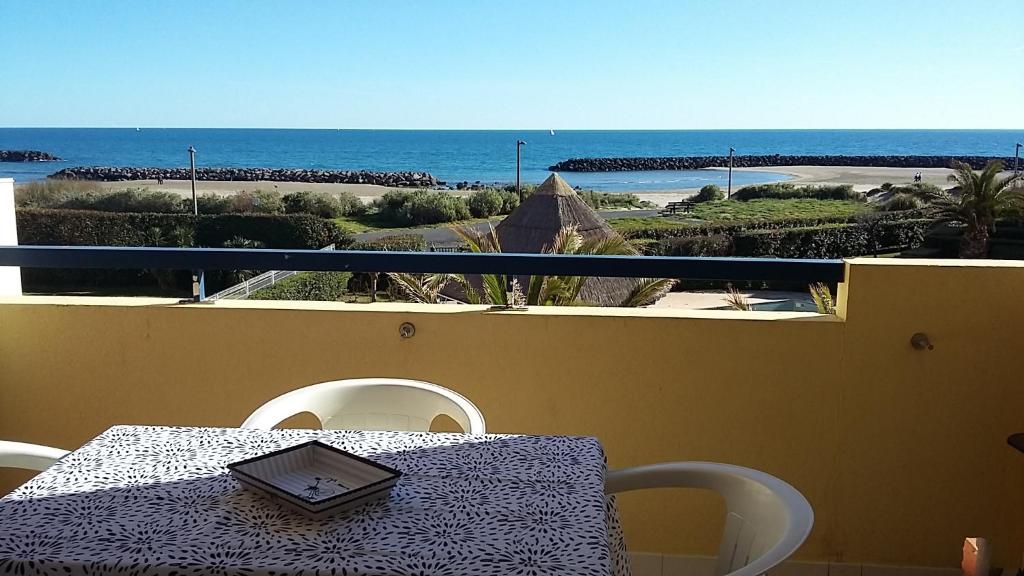 - une table sur un balcon avec vue sur l'océan dans l'établissement Appartement 2 Pièces Vue Mer Rochelongue CAP D'AGDE, au Cap d'Agde