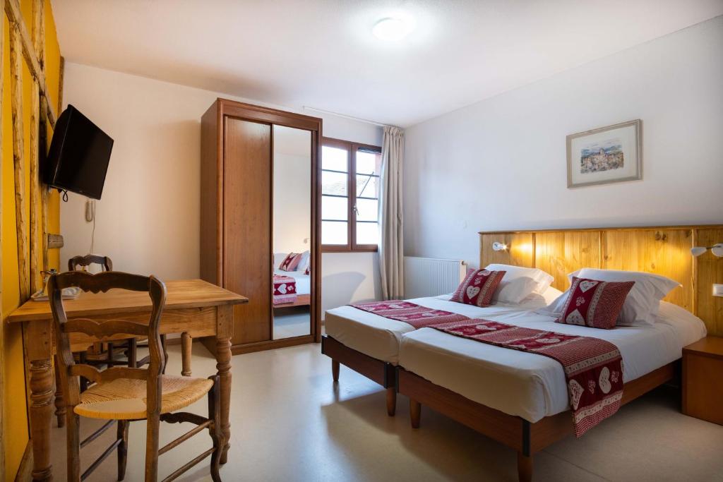 伊斯內姆的住宿－Hotel Relais d'ISSENHEIM Table d'hôtes，一间卧室配有一张床、一张桌子和一张桌子