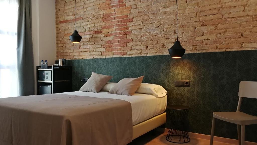 a bedroom with a bed and a lamp on the wall at Hotel Cantón in Barcelona