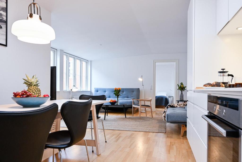 a kitchen and living room with a table and chairs at Sanders Tower - Dreamy Two-Bedroom Apartment In Charming Copenhagen in Copenhagen
