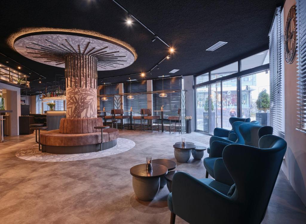 eine Lobby mit einem Baum in der Mitte eines Raumes in der Unterkunft Best Western Plus Hotel Regence in Aachen