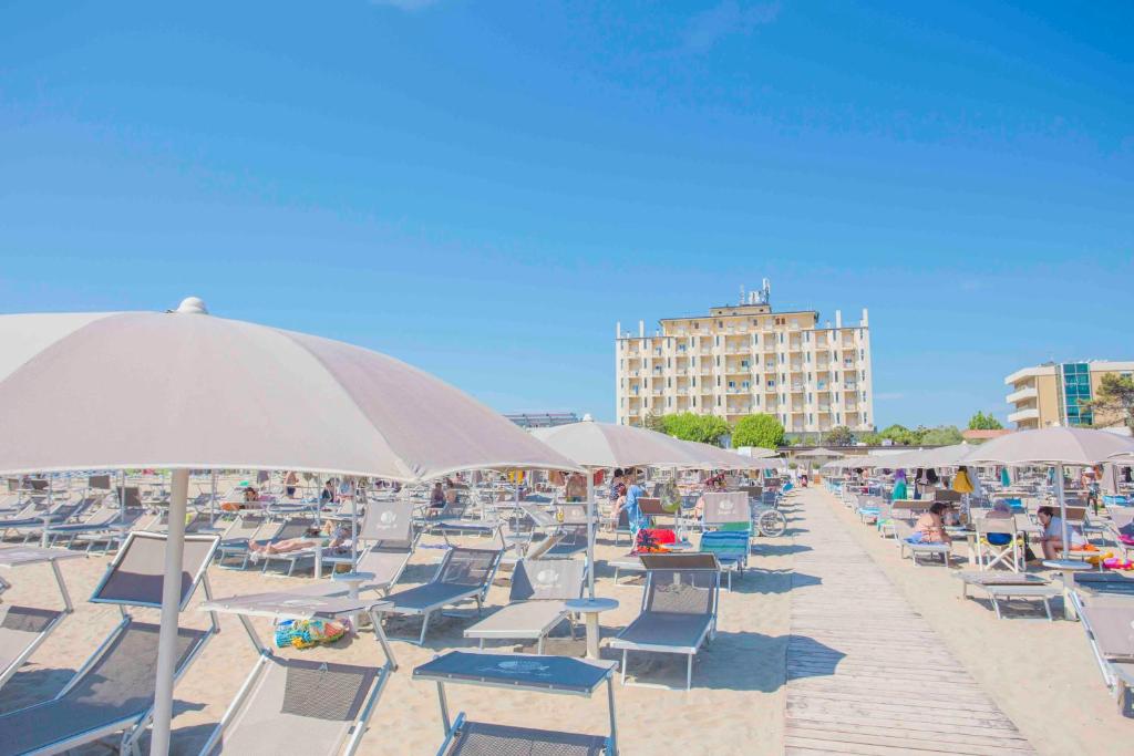 a bunch of chairs and umbrellas on a beach at Hotel Adler in Lido di Classe