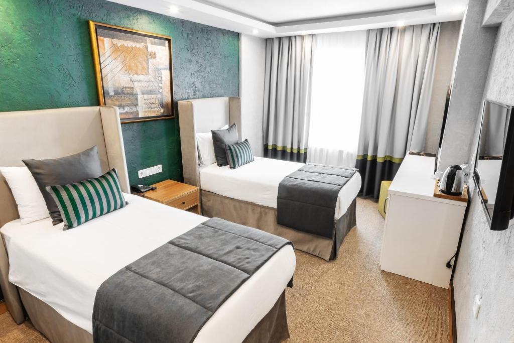 イスタンブールにあるCarlton Hotel Old Cityのベッド2台とテレビが備わるホテルルームです。