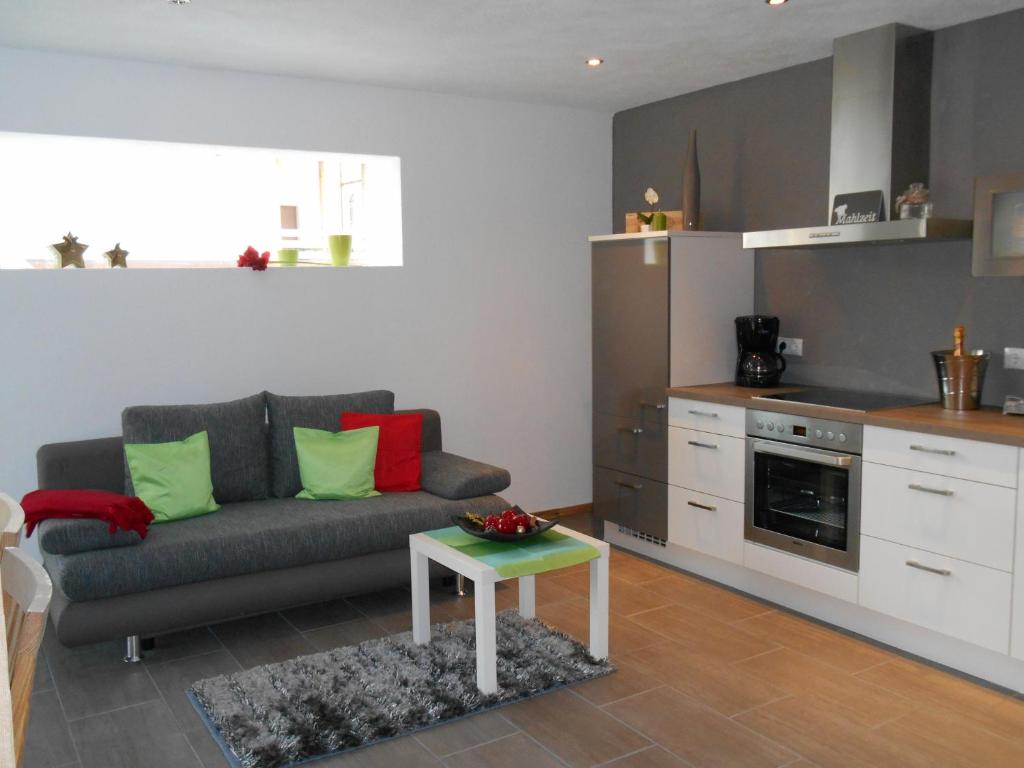 ein Wohnzimmer mit einem Sofa und einer Küche in der Unterkunft Apartment Carpe Diem in Kramsach
