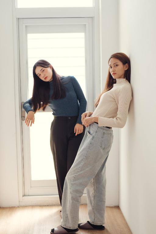 two women standing in front of a window at T-Life Hostel in Longjing