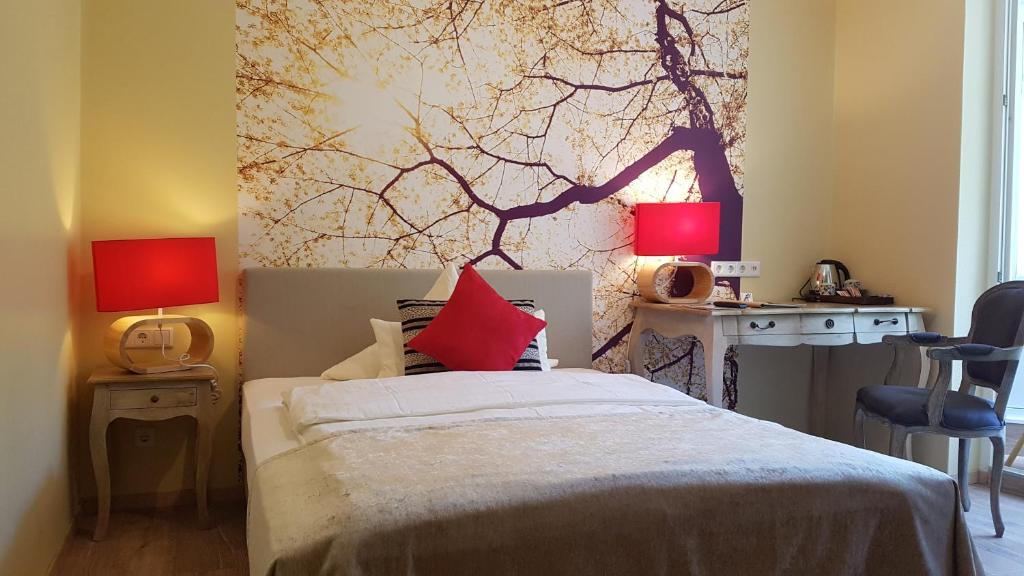 a bedroom with a bed with two lamps and a desk at Hotel Villa Verde in Düsseldorf