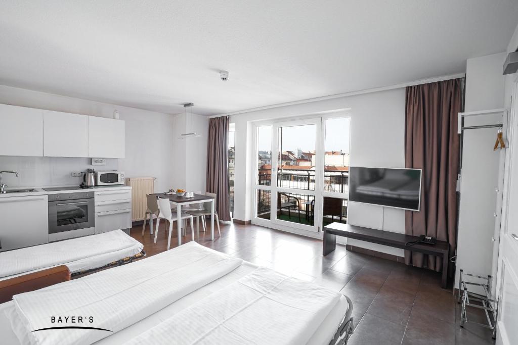 Habitación blanca grande con 2 camas y cocina. en Bayer's Boardinghouse und Hotel, en Múnich