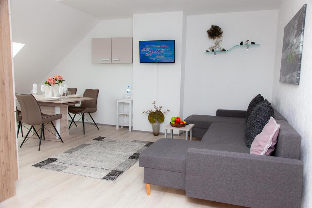 uma sala de estar com um sofá cinzento e uma mesa em T&K Apartments near Messe Fair Trade Düsseldorf und Airport 3B em Duisburg