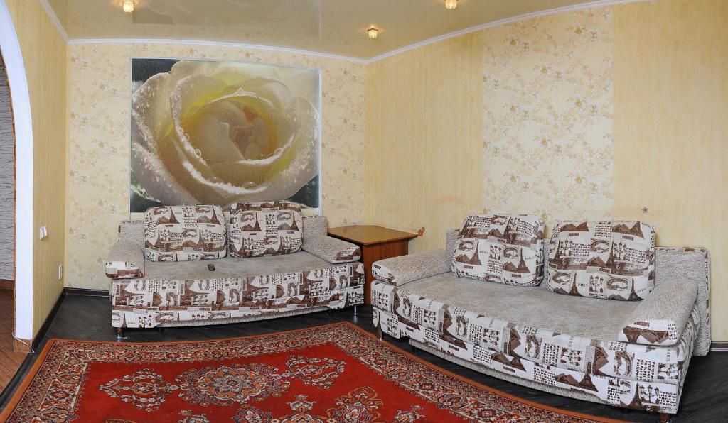 オムスクにあるOmsk Sutki Apartments on Sportivnyi proezd 12のリビングルーム(ベッド2台、ラグ付)