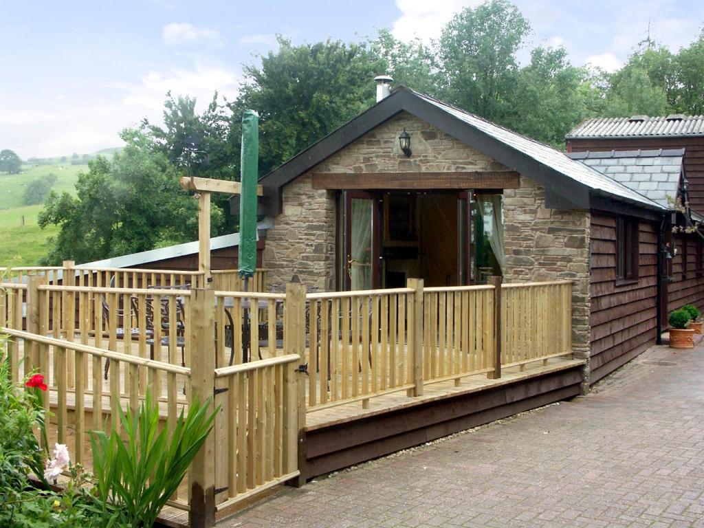 una piccola cabina con una recinzione in legno di fronte ad essa di Cwm Derw Cottage a Llanafan-fawr
