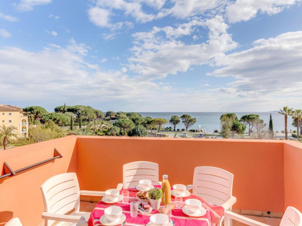 una mesa y sillas en un balcón con vistas al océano en Apartment Les Rivages des Issambres-3 by Interhome, en Les Issambres