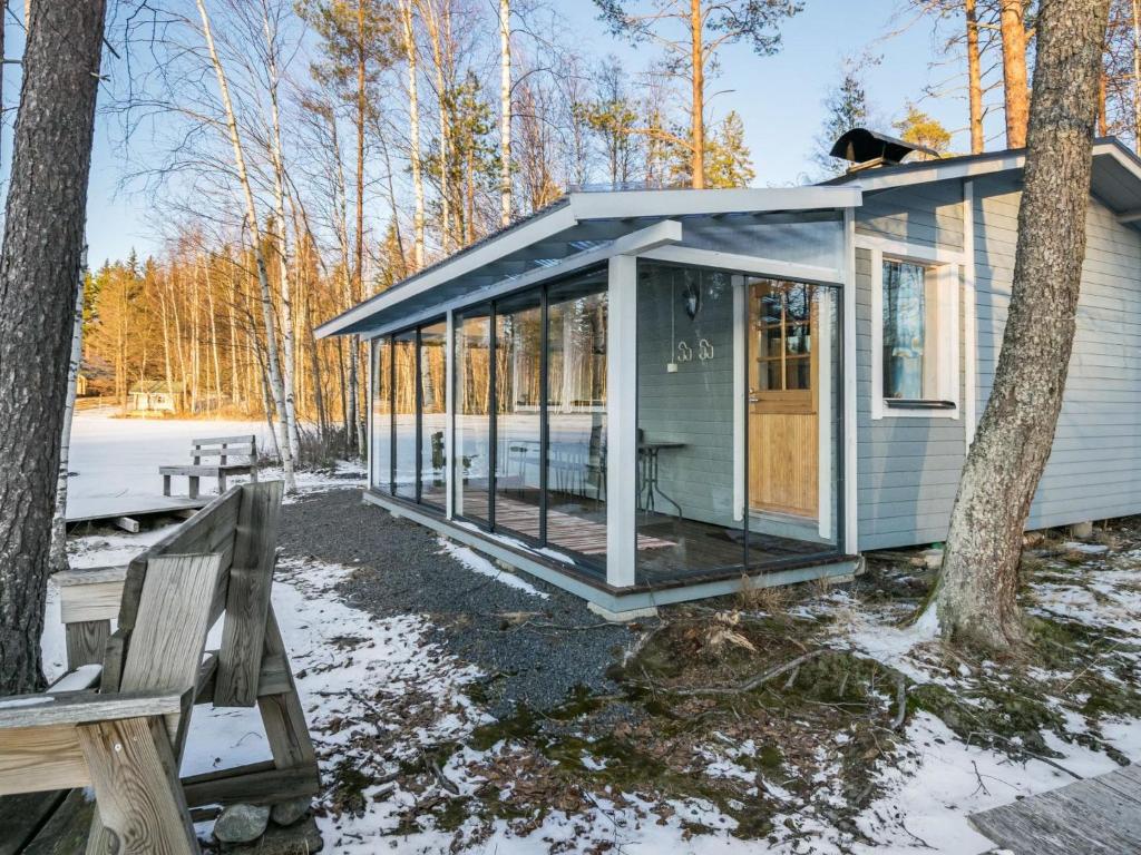 a tiny house in the woods with a porch at Holiday Home Hukka 6 by Interhome in Harkala