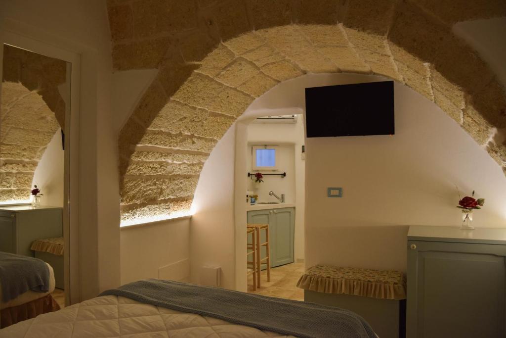 a bedroom with a bed and a tv on a wall at Leavì in Polignano a Mare