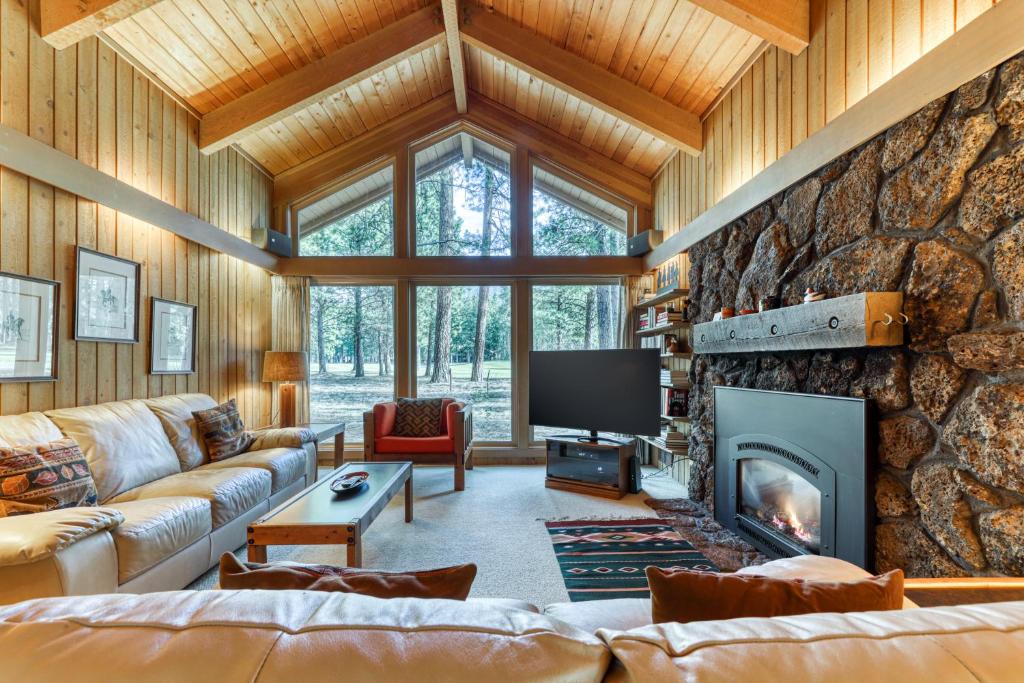 uma sala de estar com uma grande parede de pedra em Bracken Lane Golf Retreat (GH 86) em Black Butte Ranch