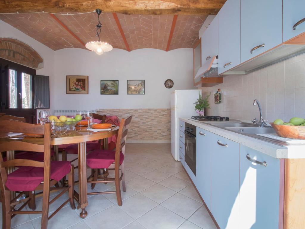 kuchnia ze stołem, krzesłami i lodówką w obiekcie Apartment Il Secondo-2 by Interhome w mieście Bibbona